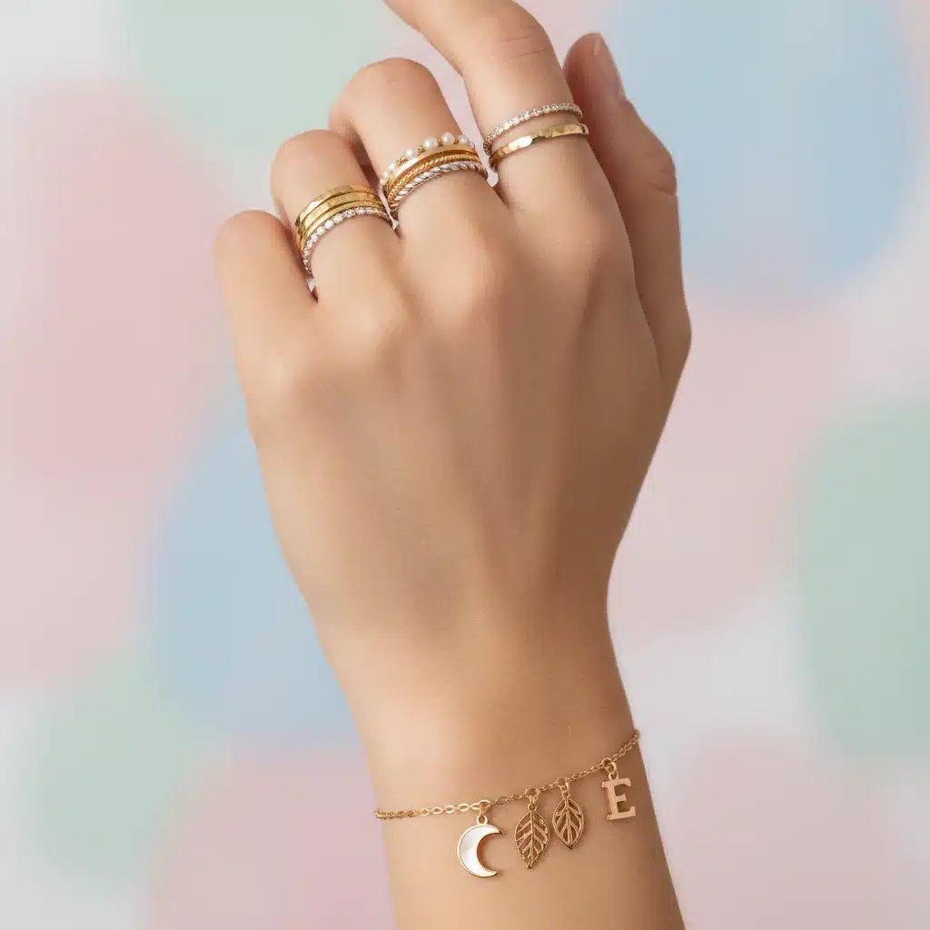 Close-up of stacked delicate rings and a charm bracelet on a hand.